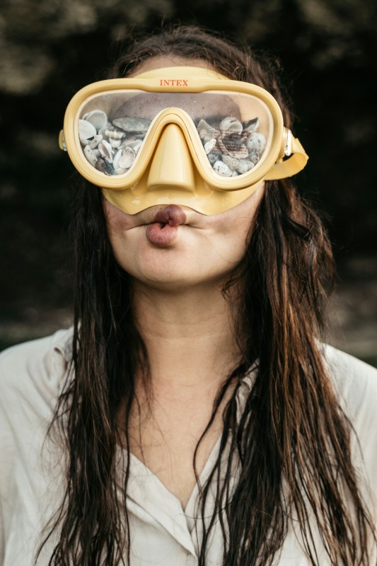 Woman acting like a jerk on purpose making a stupid face and wearing goggles with stones in them.